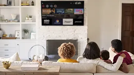 A family watches DISH streaming options on a TV above a fireplace.